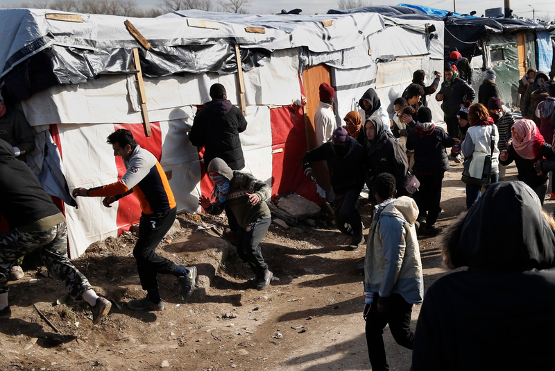 French police begin firing tear gas at migrants in the Calais camp (AP Photo/Jerome Delay)